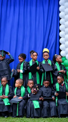 Les diplômés de la maternelle en toge noire et étole verte